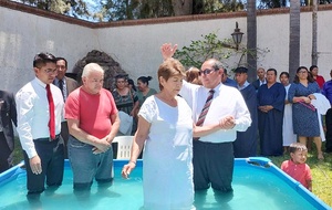 Maria de Jésus Alemán (right) is prayed for before she is baptized by Pastor Erik Segundo in Tlajomulco, Gudalajara. She invited Carlos Gutiérrez (left) to a bible study group on Zoom and he decided to be baptized as well on Apr. 22, 2023. Both were among more than 300 persons who joined the church at the close of historic evangelistic efforts in Guadalajara, in the North Mexican Union leading up to the national campaign in June. [Photo: North Mexican Union]